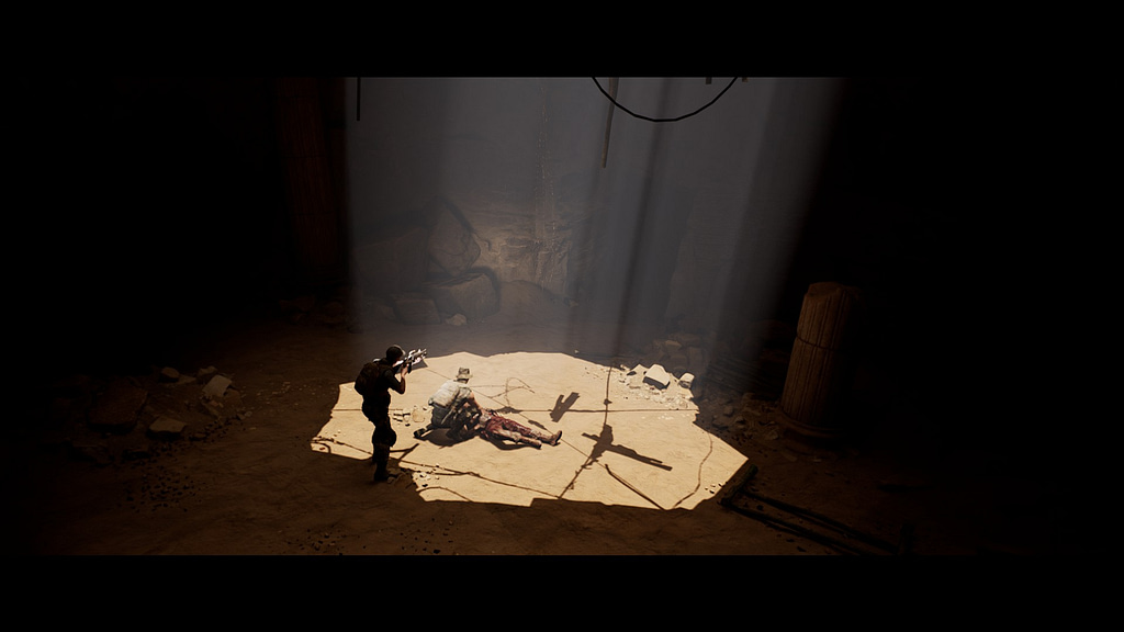 Image descriptor: A screenshot from House of Ashes. A dark cavern is illuminated by a small crack in the rocks above, which shine light upon two soldiers. One is standing and pointing his gun into the darkness. The other is kneeling over a dead body.
