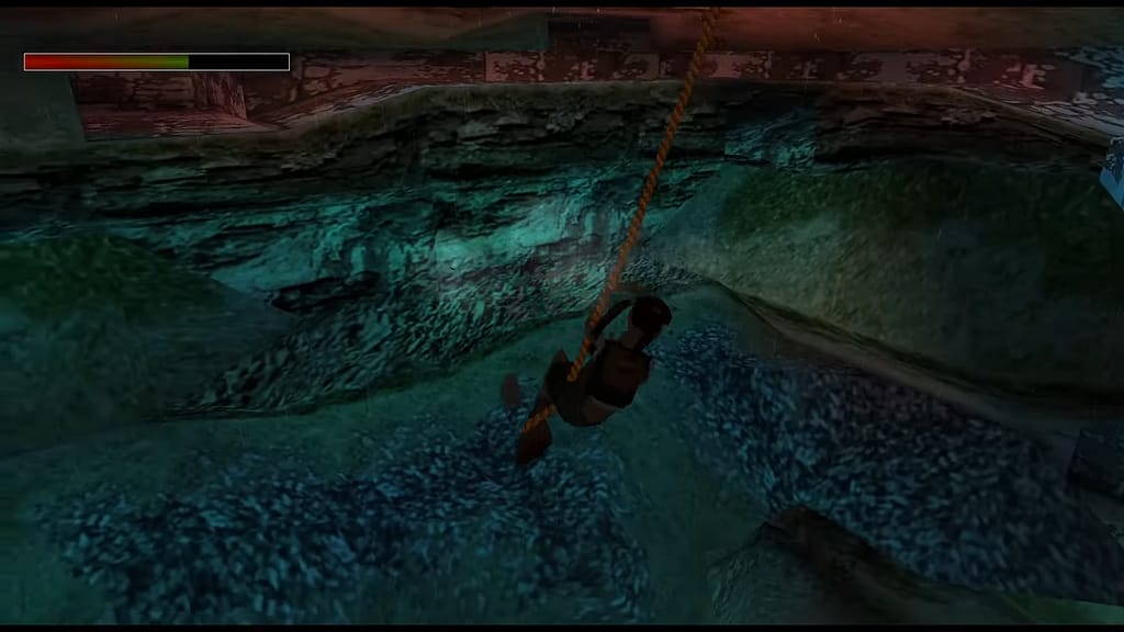 Image Descriptor: A teenage Lara Croft swings on a long rope over a cavern in a rocky yet grass coated area.