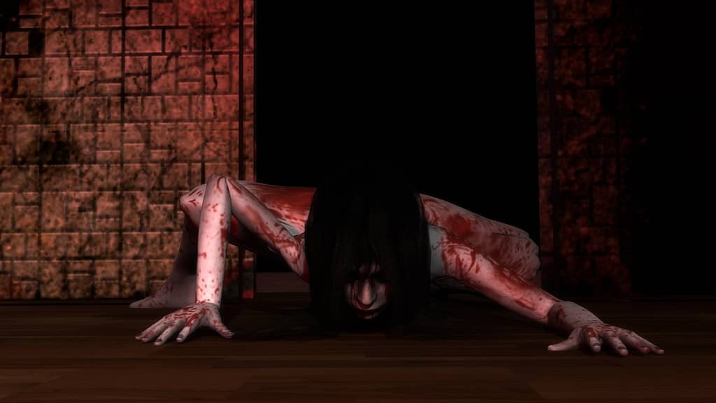 Image descriptor: Kayako Saeki crawls along the ground in front of a pitch black doorway, coated in blood. The walls around here are slick with cracks and decay.
