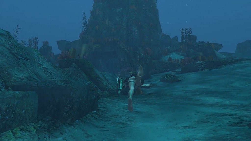 Image Descriptor: Lara can be seen swimming deep within the Mediterranean Sea, with a huge sunken structure of mossy ruins up ahead, just begging to be explored.