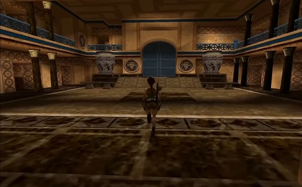 Image Descriptor: Lara runs through a large regal room of blues and golds, with a large door ahead of her, decorated with two gigantic vases to either side. Numerous doorways sprout off from both sides of the room.