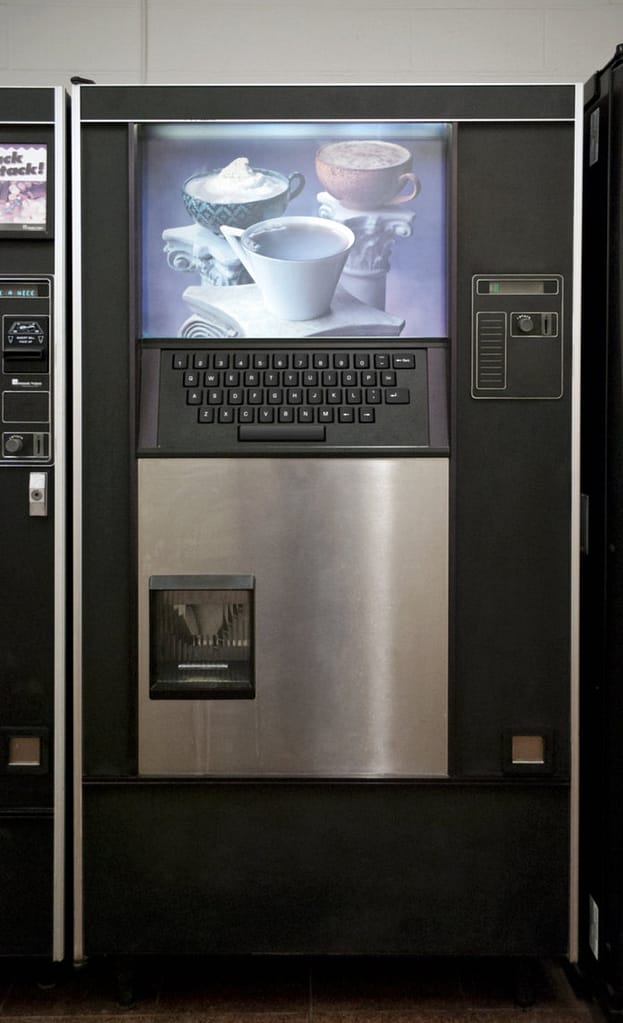Image descriptor: An image of SCP-294, taken from the SCP Foundation Wikipedia. It looks like a perfectly traditional coffee machine, albeit with a full sized computer keyboard built into it.